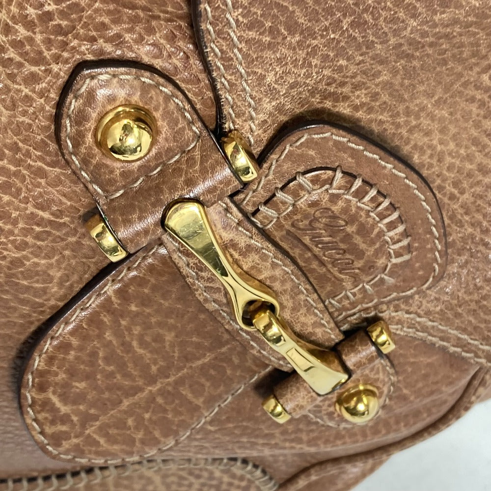 Close-up of a brown leather bag with gold hardware