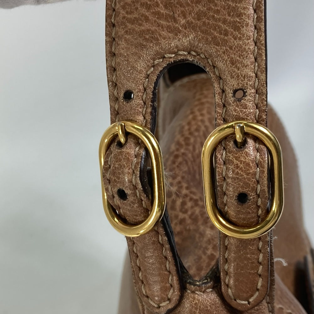 Close-up of a brown leather strap with gold oval buckles on a white background