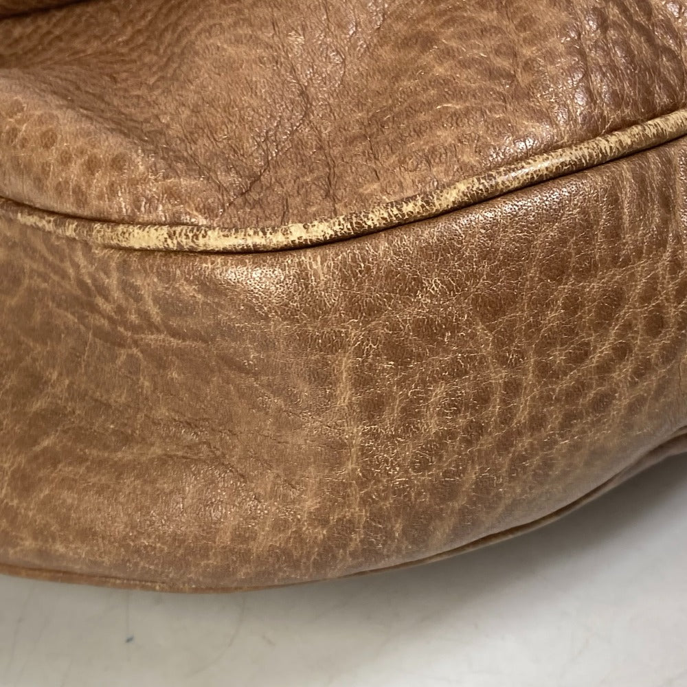 Close-up of a brown leather ottoman on a light gray background