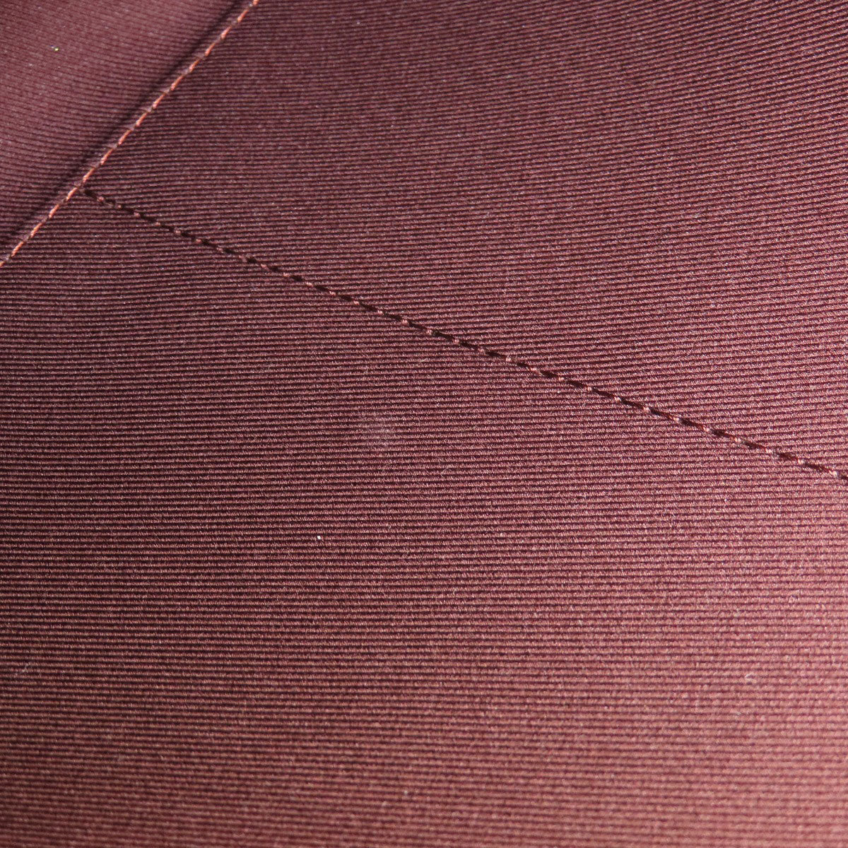 Close-up of a maroon fabric with a visible seam
