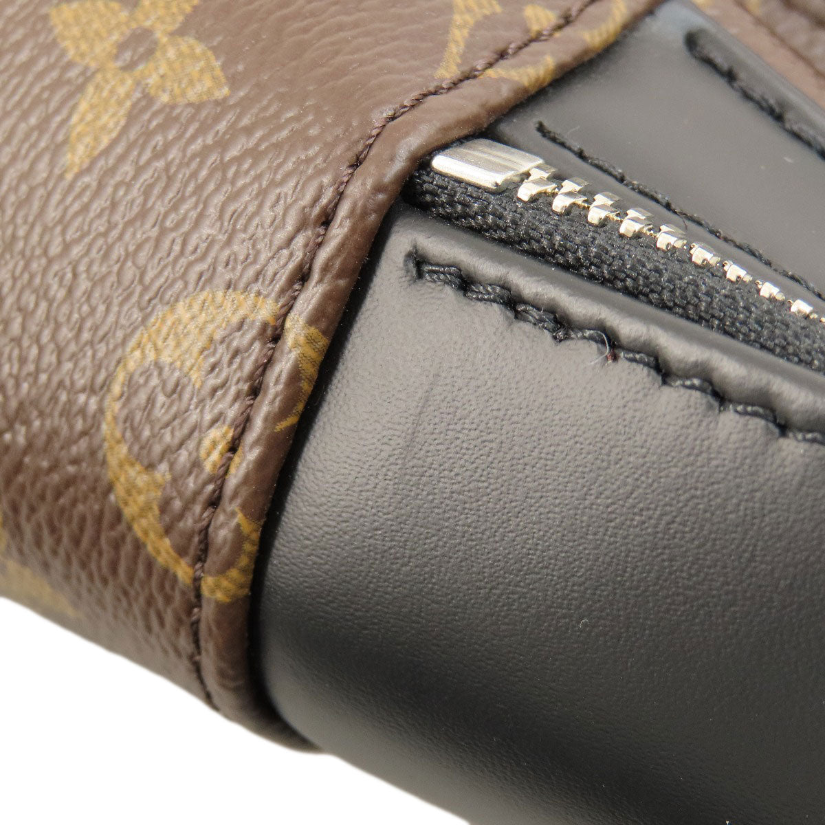 Close-up of a brown leather wallet with gold floral pattern and black interior.