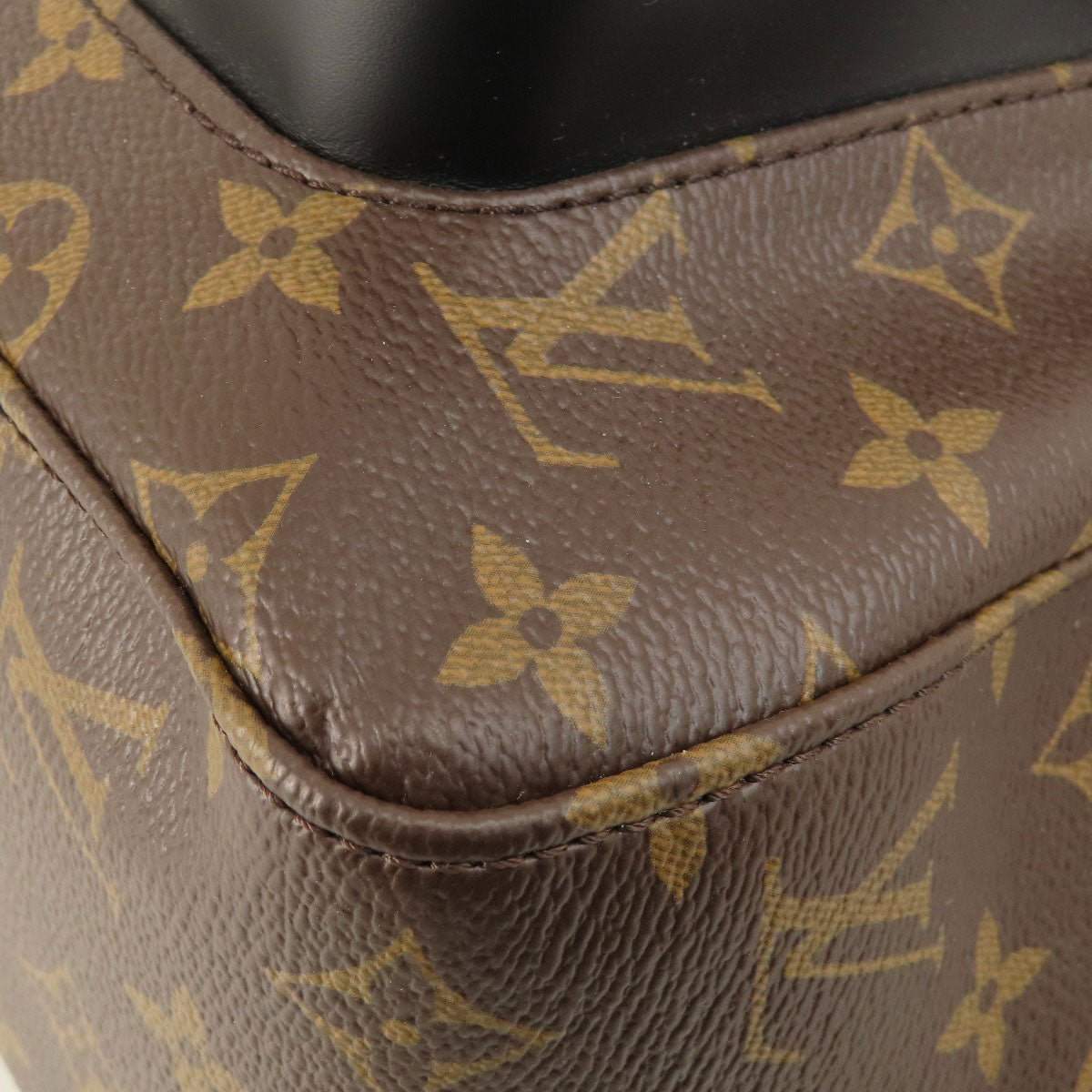 Close-up of a brown leather product with a distinctive pattern, likely a Louis Vuitton bag.