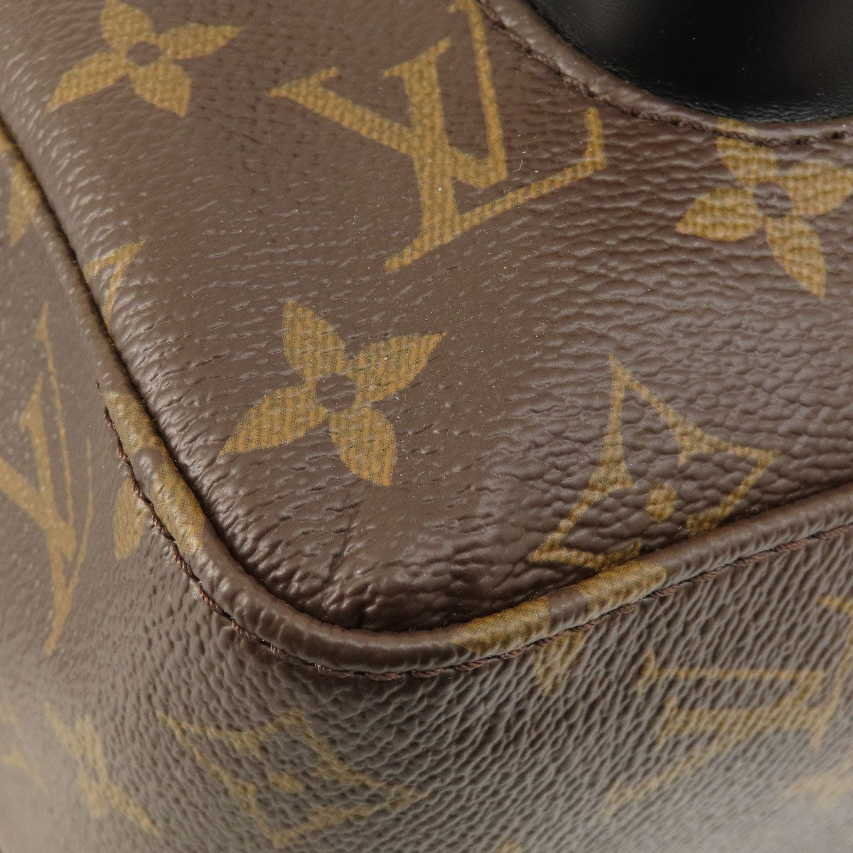Close-up of a brown leather bag with gold monogram pattern
