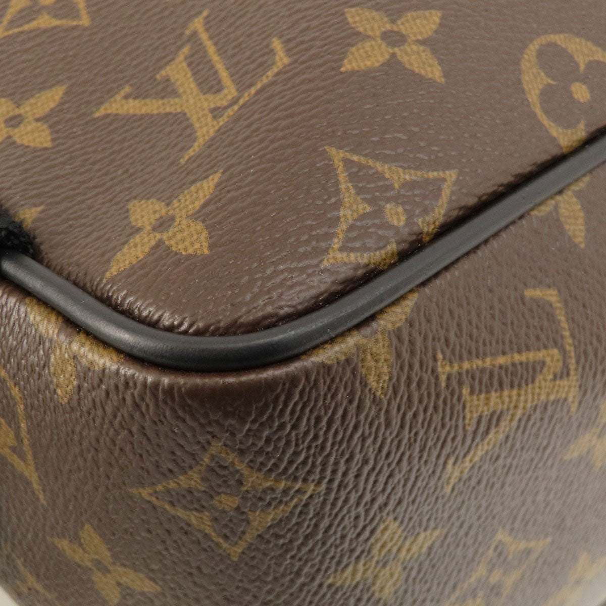 Close-up of a brown leather product with a gold monogram pattern