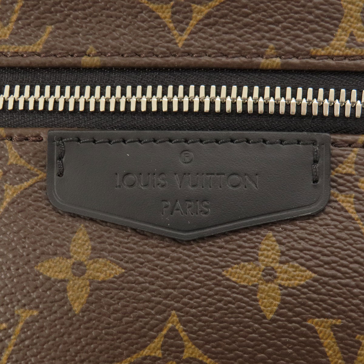 Close-up of a Louis Vuitton bag with monogram pattern and brand logo.