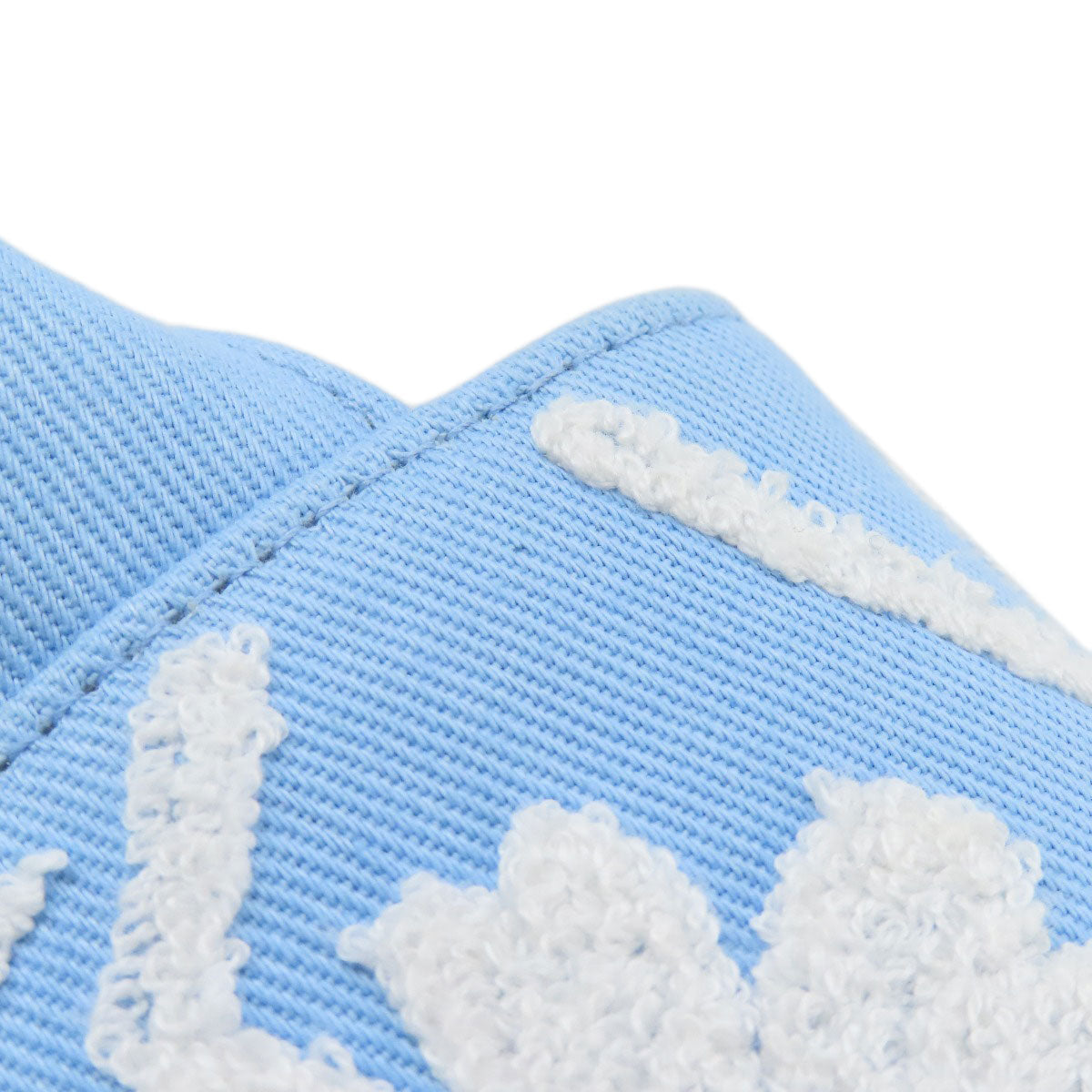Close-up of a blue shoe with white floral patterns on a white background