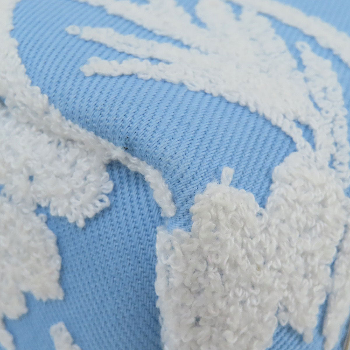 Close-up of a blue fabric with white embroidered floral patterns