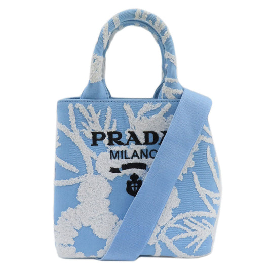 Blue Prada handbag with white floral pattern on a white background