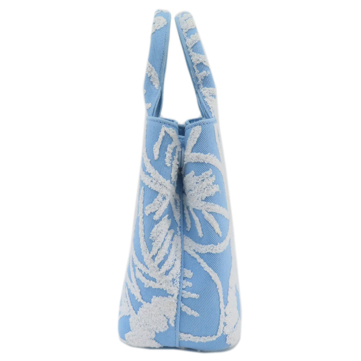 Blue tote bag with white floral pattern on a white background