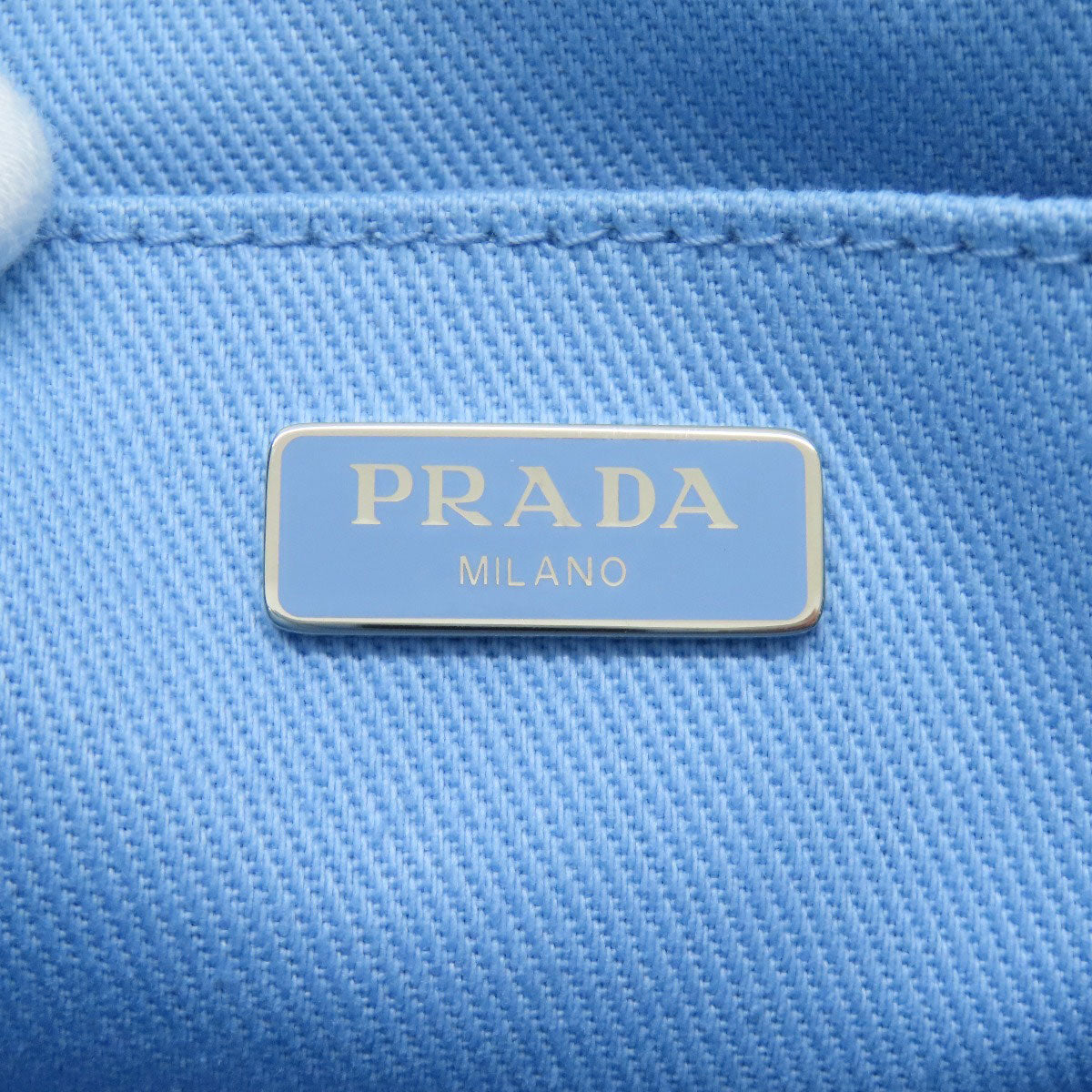 Prada logo on a blue textured background