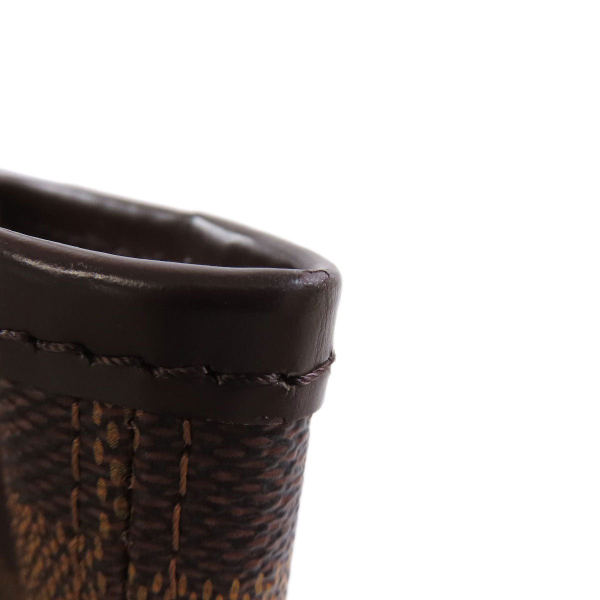 Close-up of a brown leather product with stitching detail on a white background