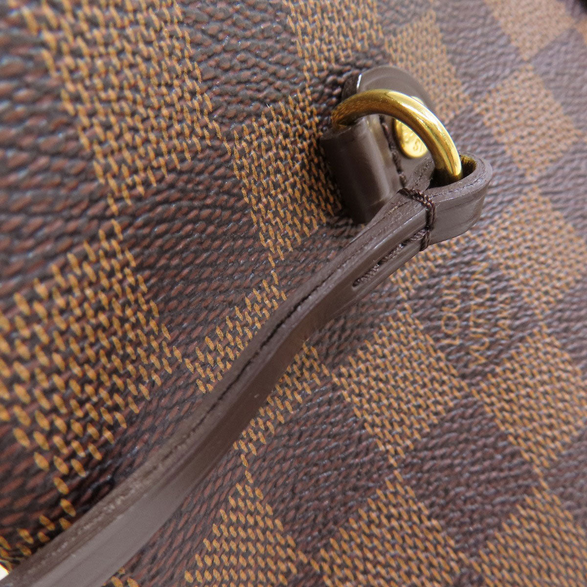 Close-up of a brown textured bag with a gold zipper pull.
