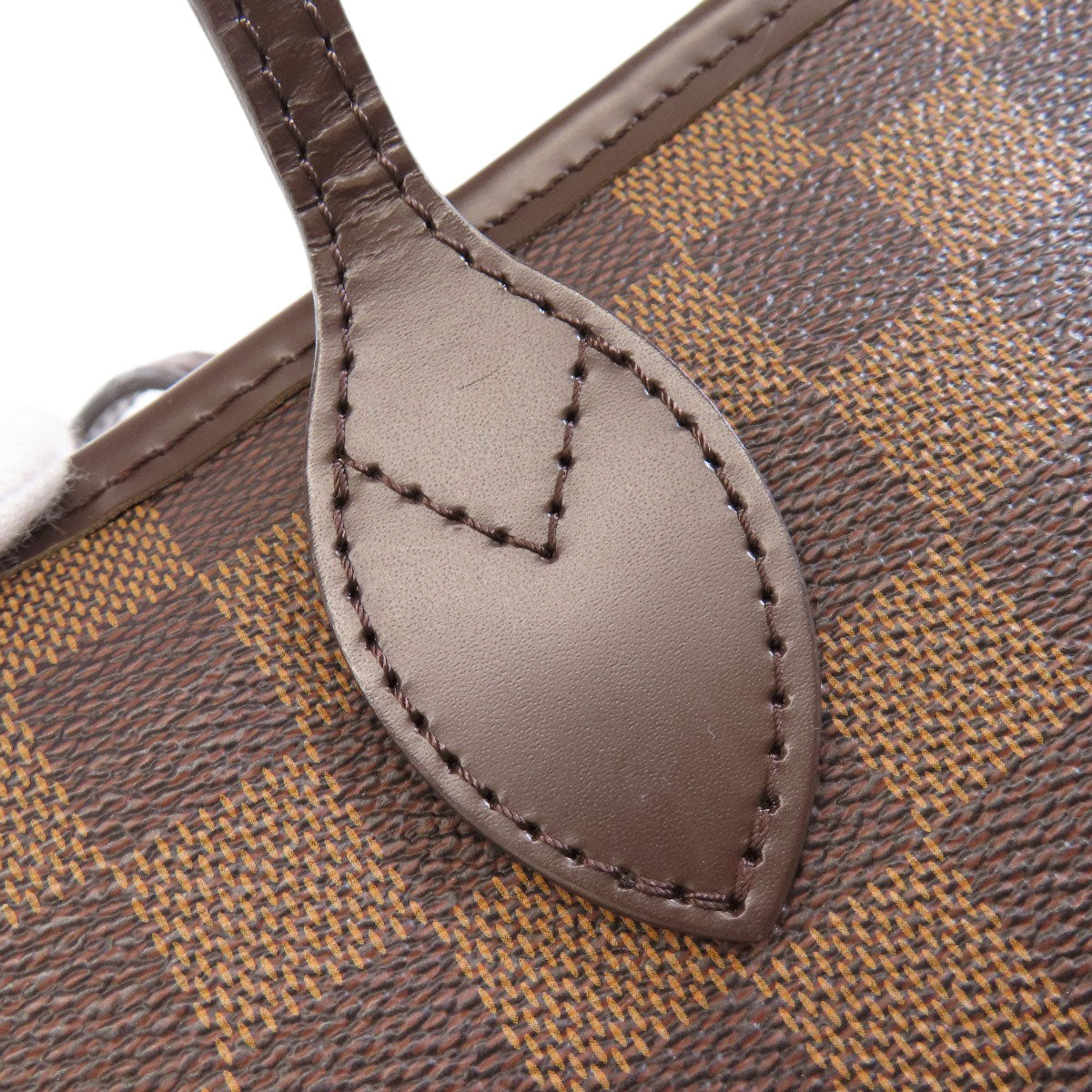 Close-up of a brown leather tag on a patterned fabric surface