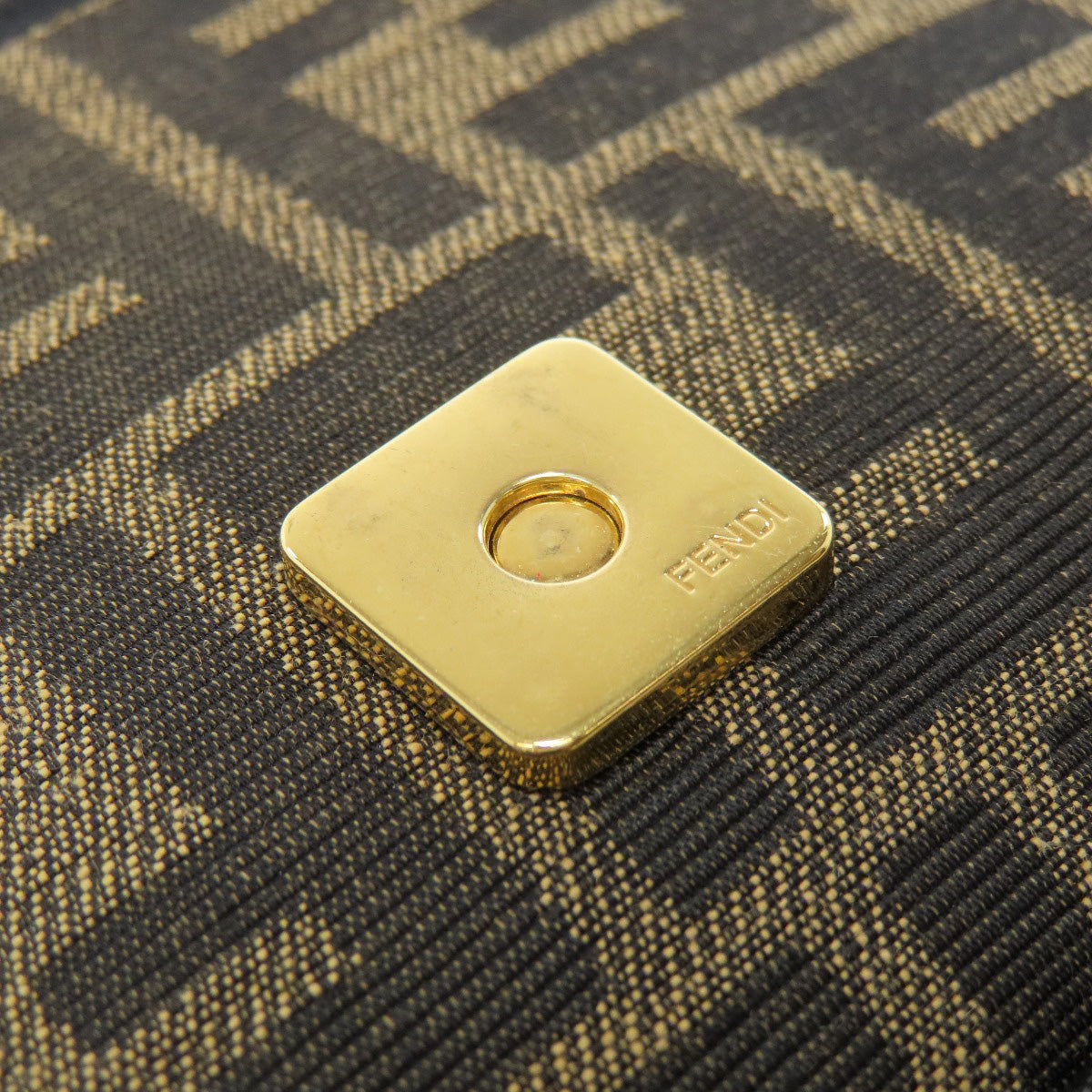 Gold square tag with 'Benu' branding on a textured black and gold fabric background