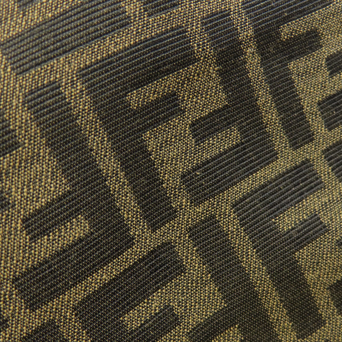 Close-up of a textured fabric with a geometric pattern in black and brown.