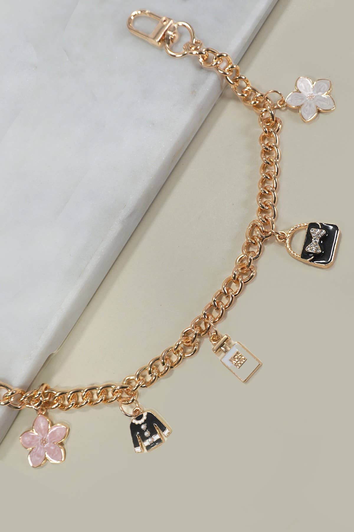 Gold bracelet with various charms on a light background