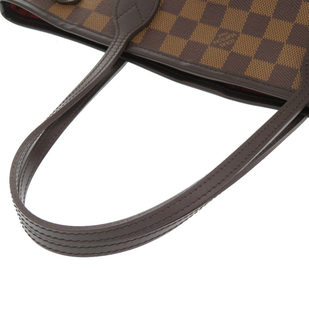 Close-up of a brown checkered handbag with a visible brand logo on a white background