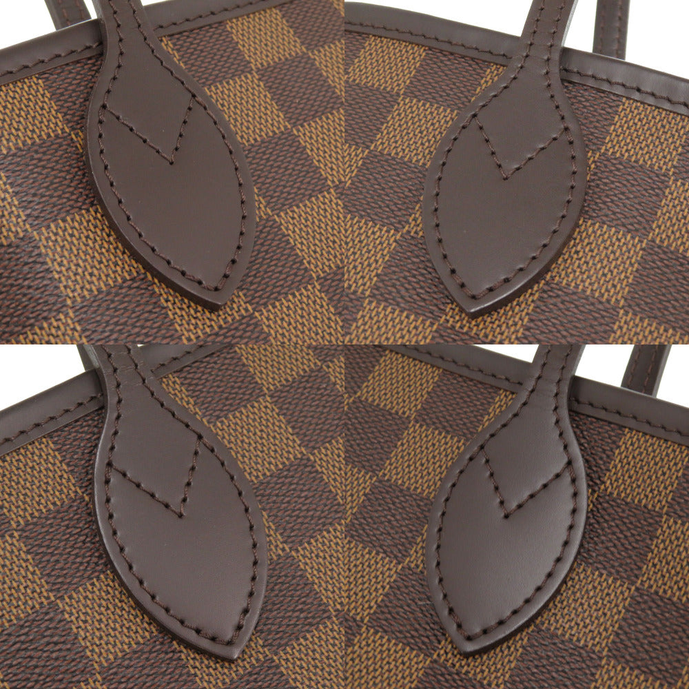 Close-up of a brown and beige checkered handbag with leather handles.