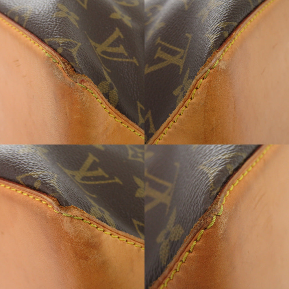 Close-up of a brown leather bag with monogram pattern, showing texture and stitching details.