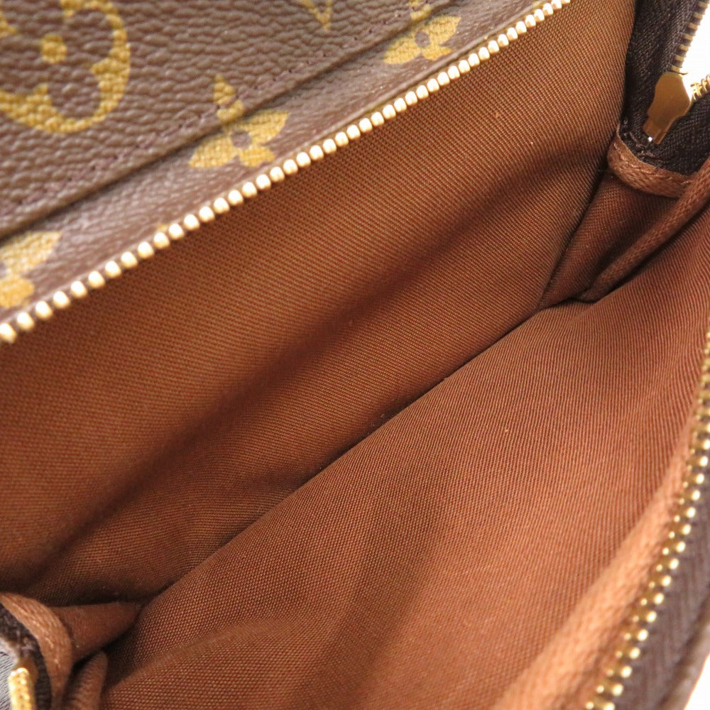 Close-up of a brown leather bag with gold zipper and pattern