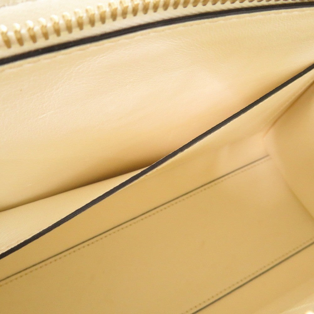 Close-up of a beige leather bag with a zipper
