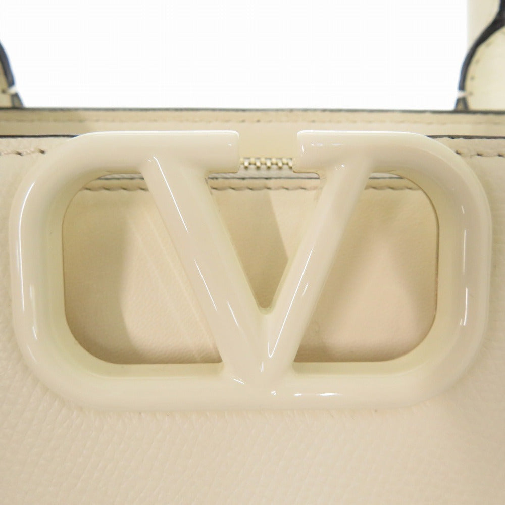 Close-up of a beige handbag with a prominent 'V' logo.