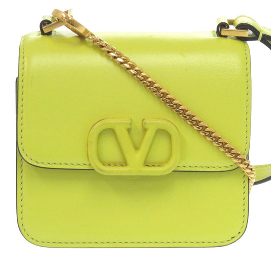Neon green handbag with gold chain strap on a white background