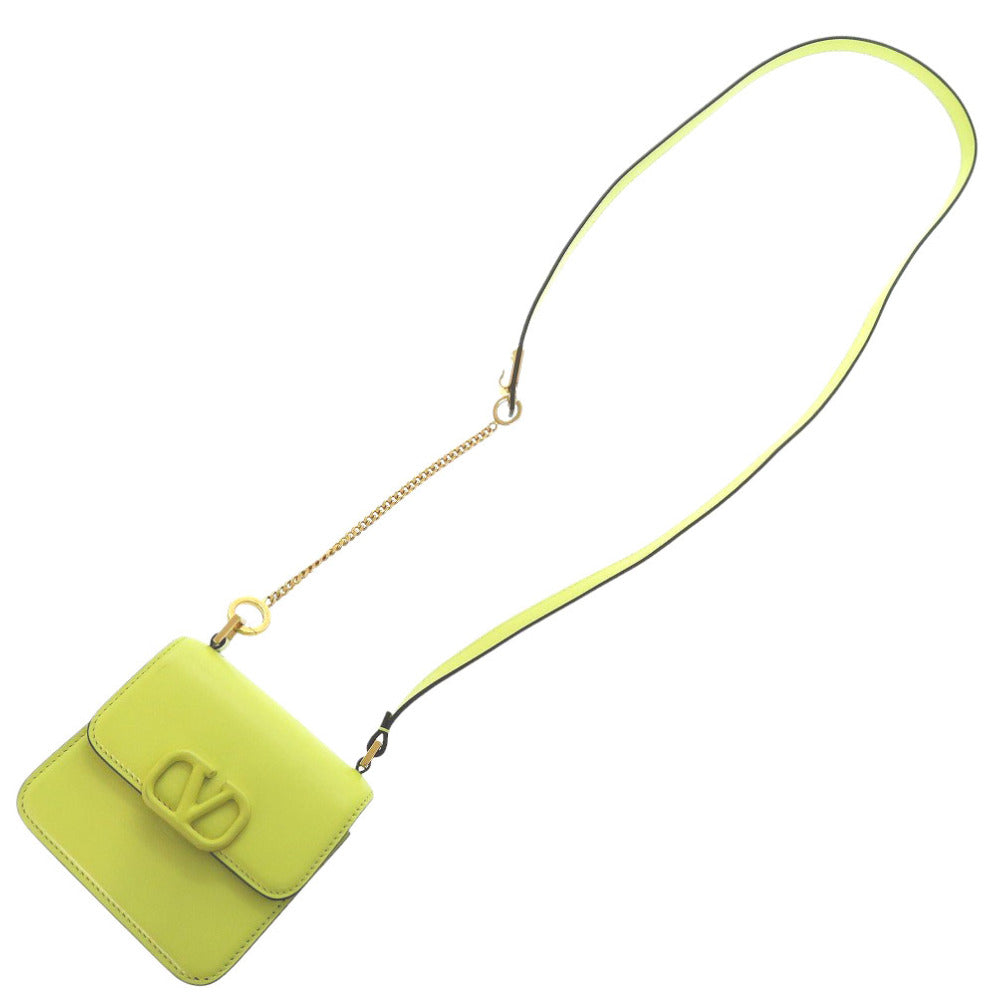 Green handbag with a chain strap on a white background