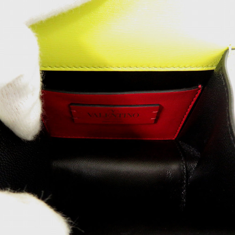 Close-up of a black leather product with a red label featuring the brand name on a white background.
