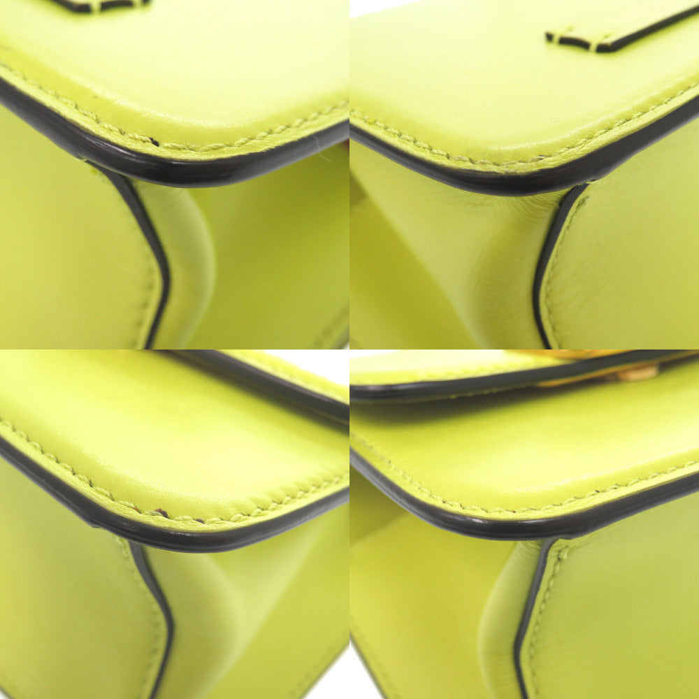 Close-up of a yellow leather product with black stitching on a white background