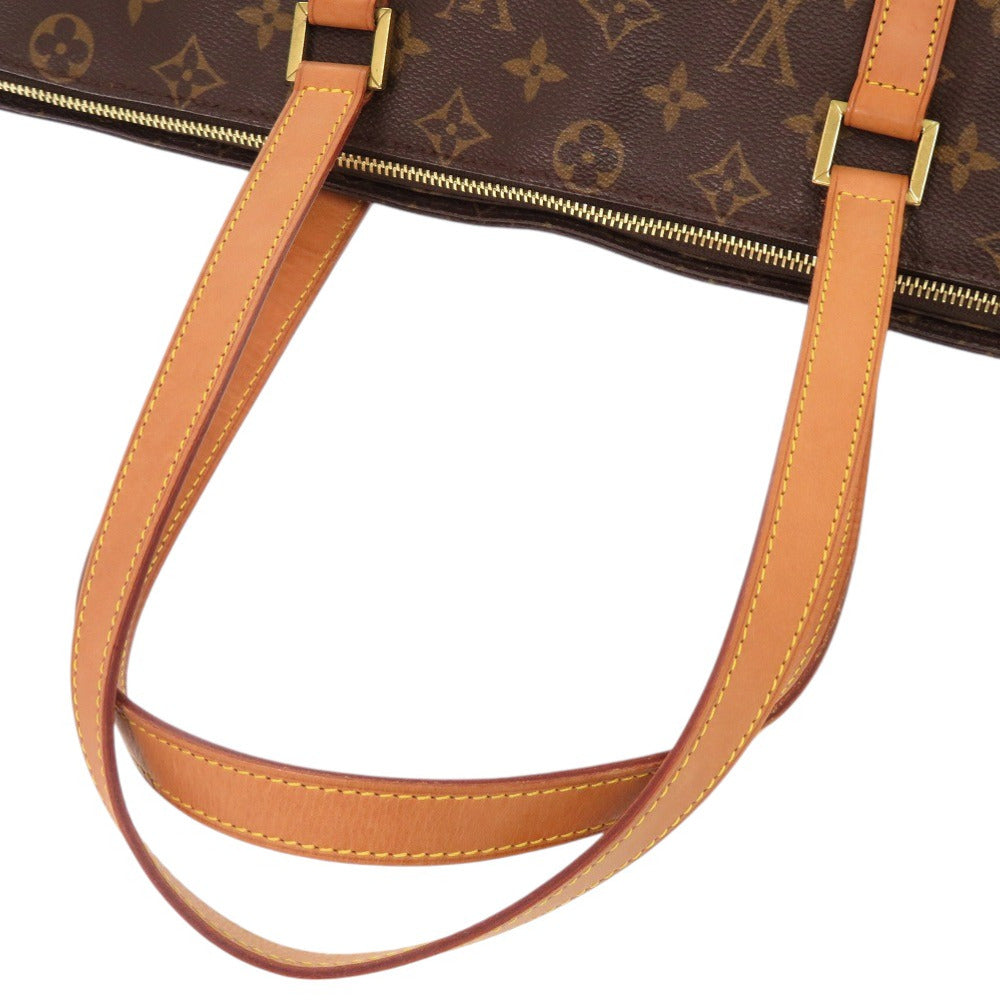 Close-up of a brown leather handbag with visible stitching and gold hardware.