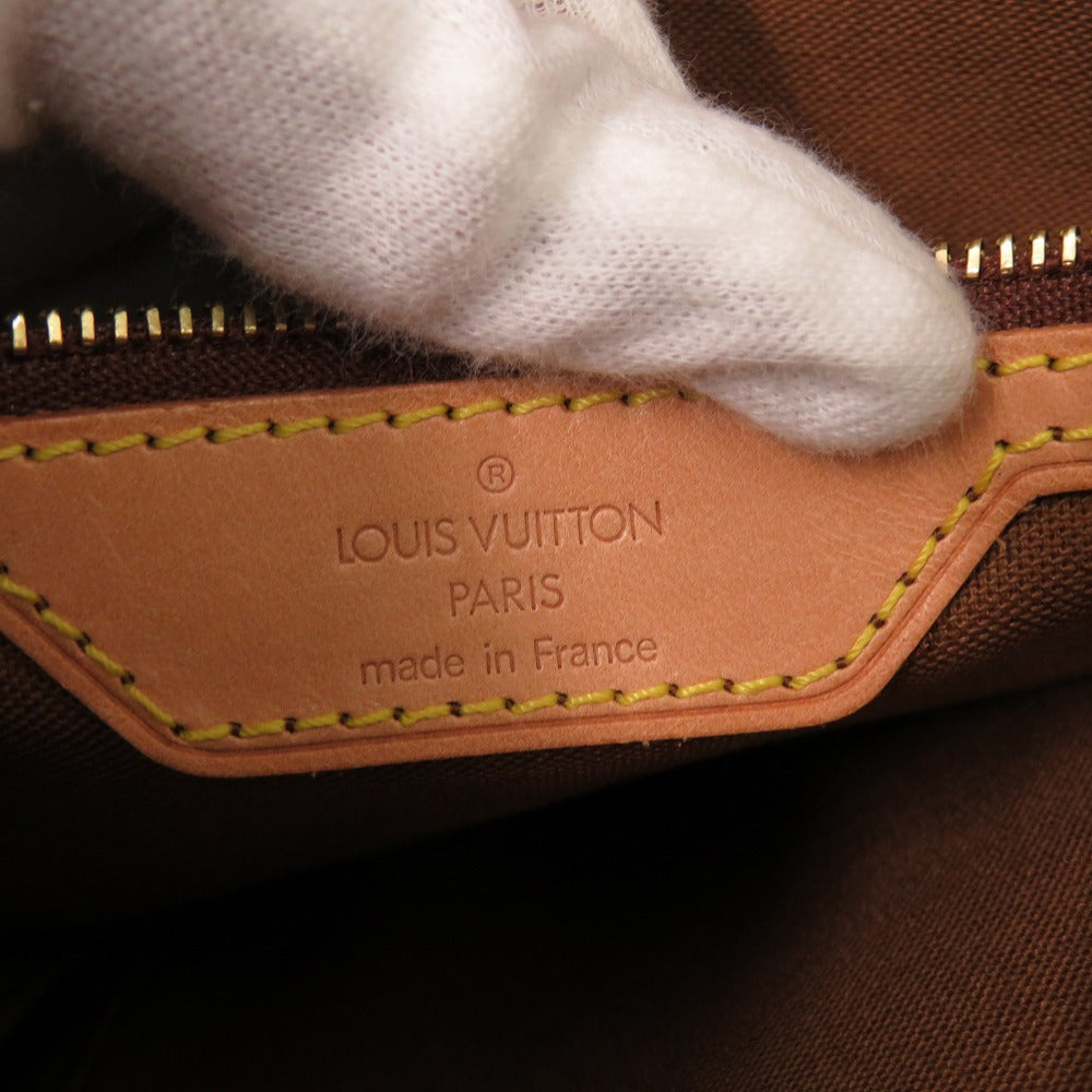 Louis Vuitton bag with a gloved hand on a brown background