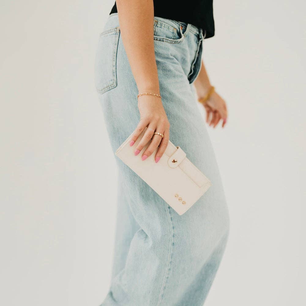 Person holding a beige wallet with a blurred background