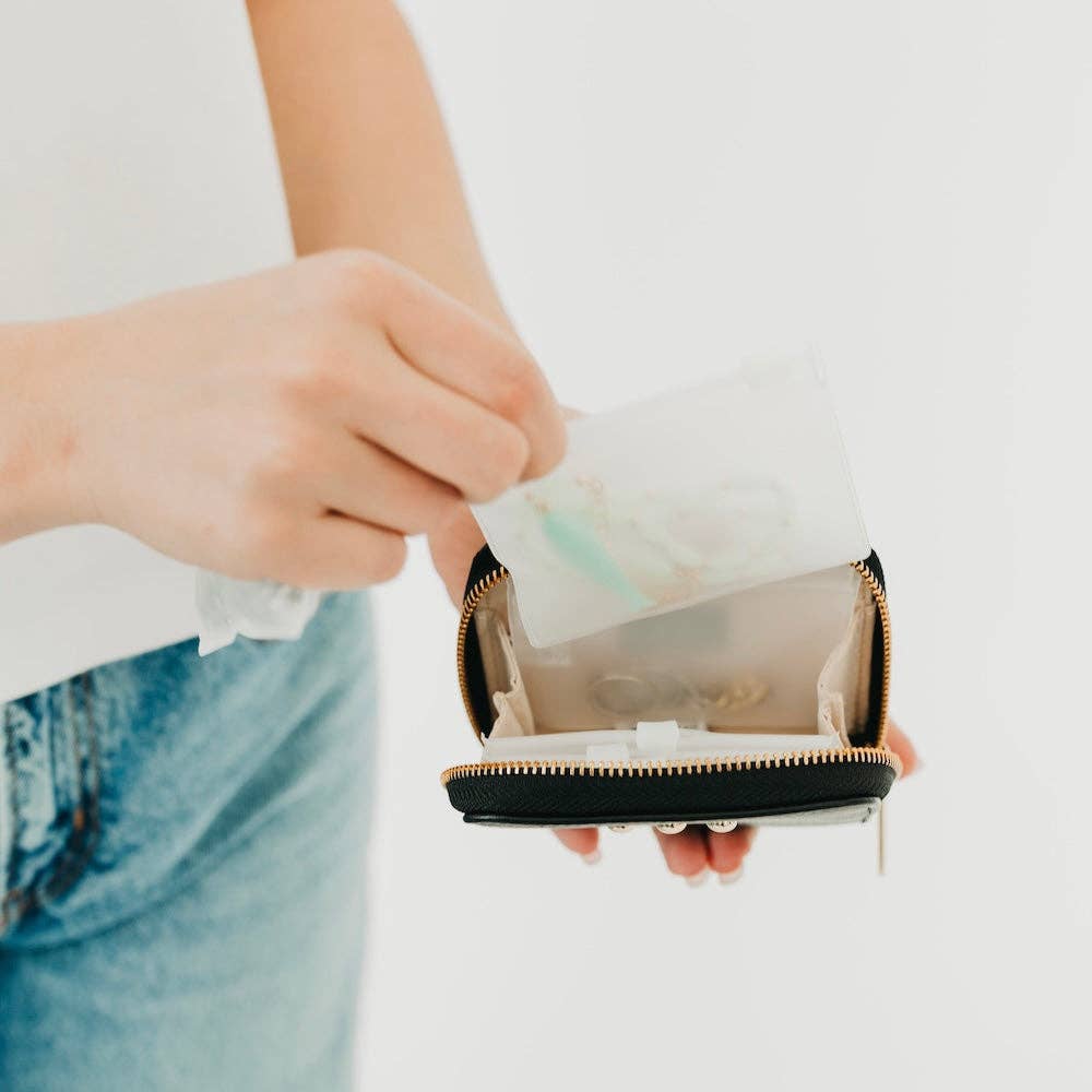 Person holding a black wallet with a white background