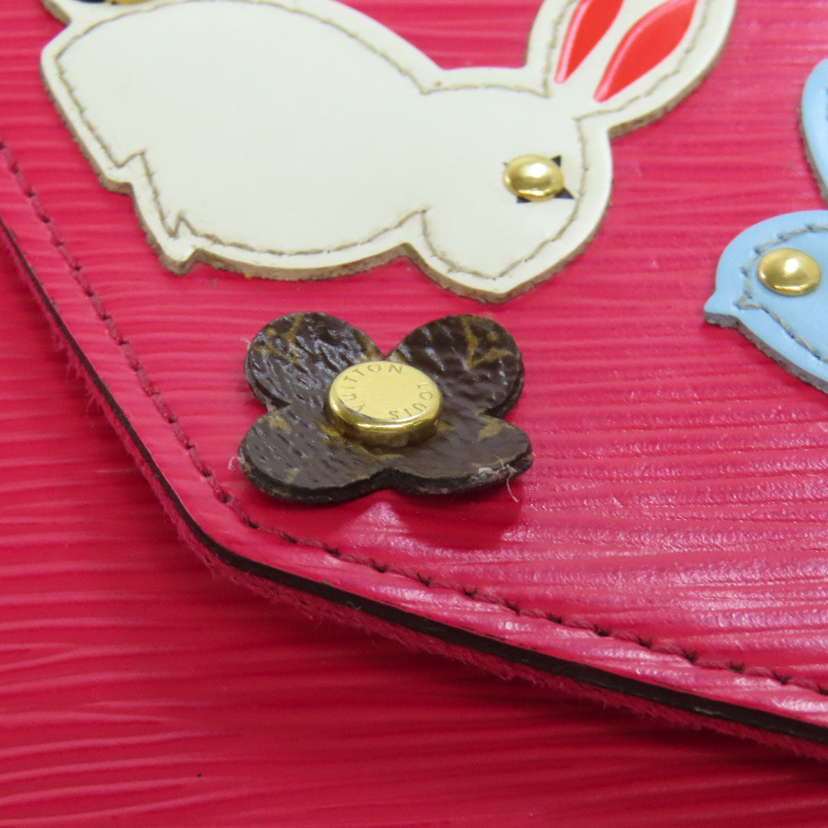 Close-up of a pink textured surface with a white rabbit design and gold accents.