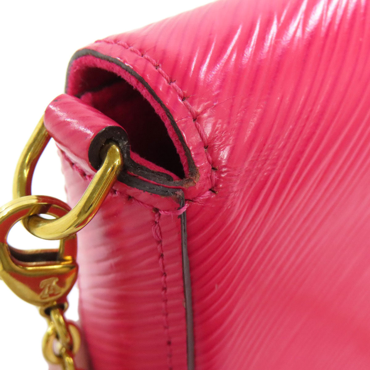 Close-up of a pink handbag with a gold chain strap on a white background