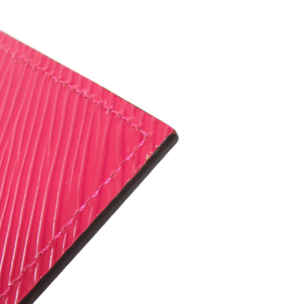 Close-up of a pink fabric with visible stitching on a white background