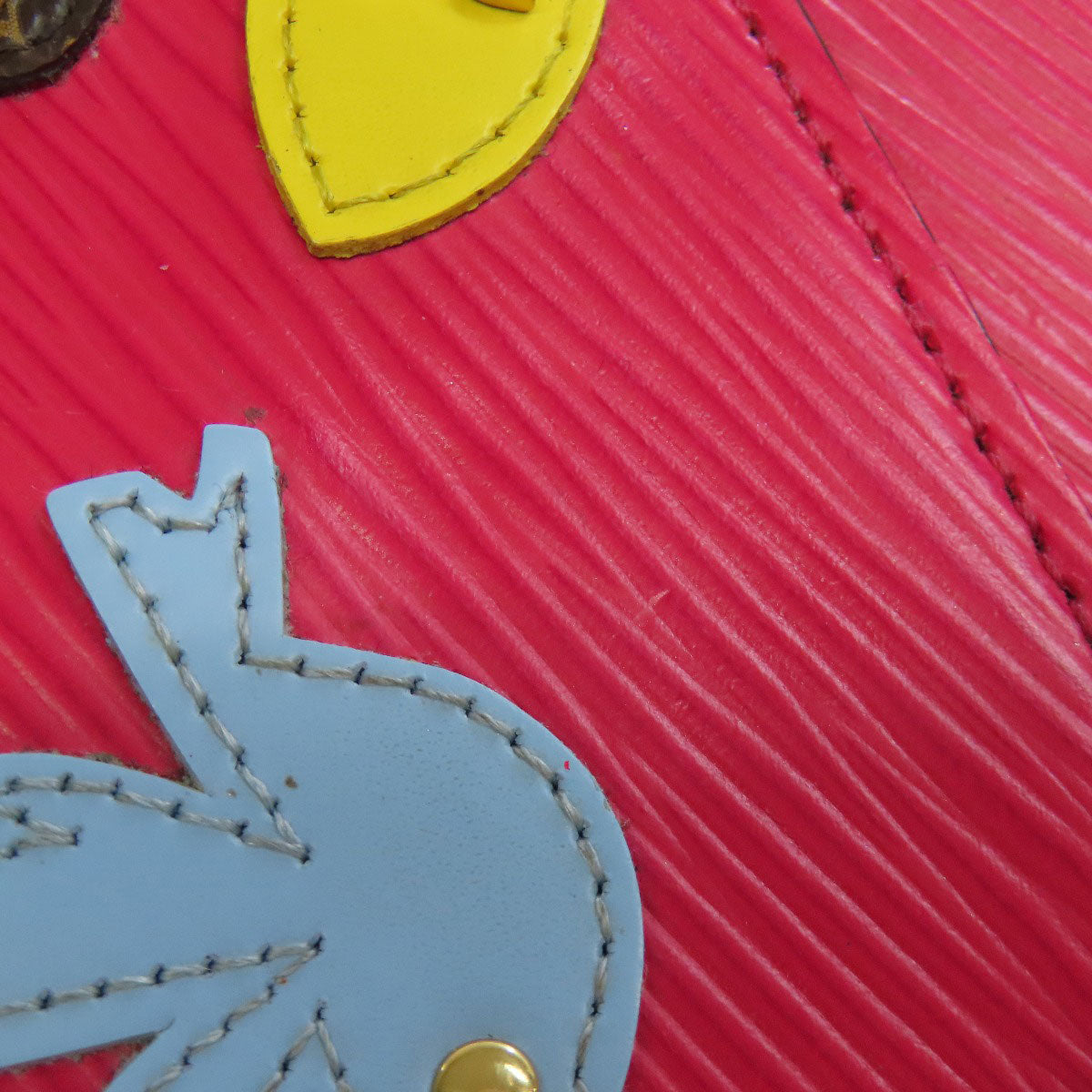 Close-up of a red textured surface with a yellow heart and blue rabbit silhouette.