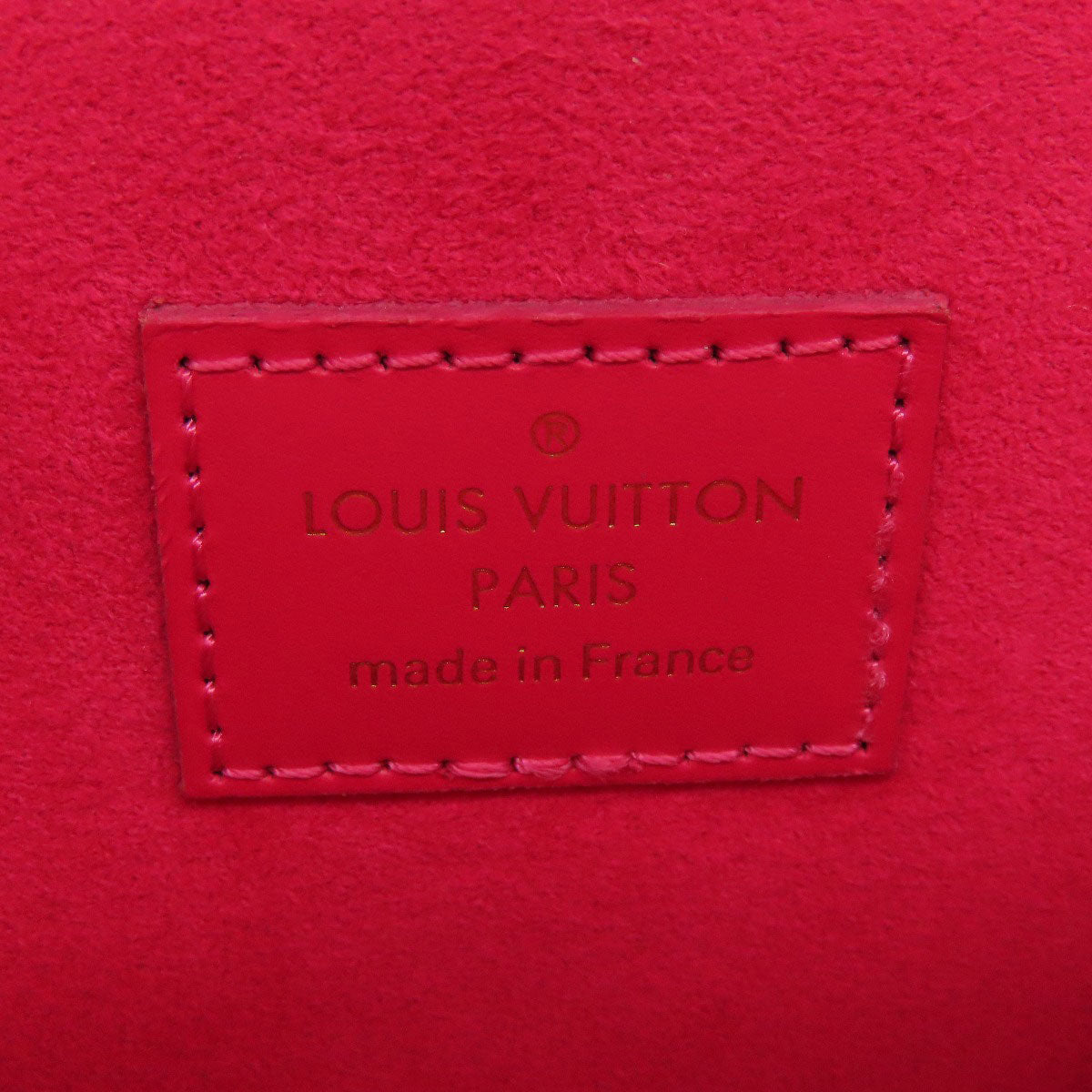 Louis Vuitton label on a red leather surface