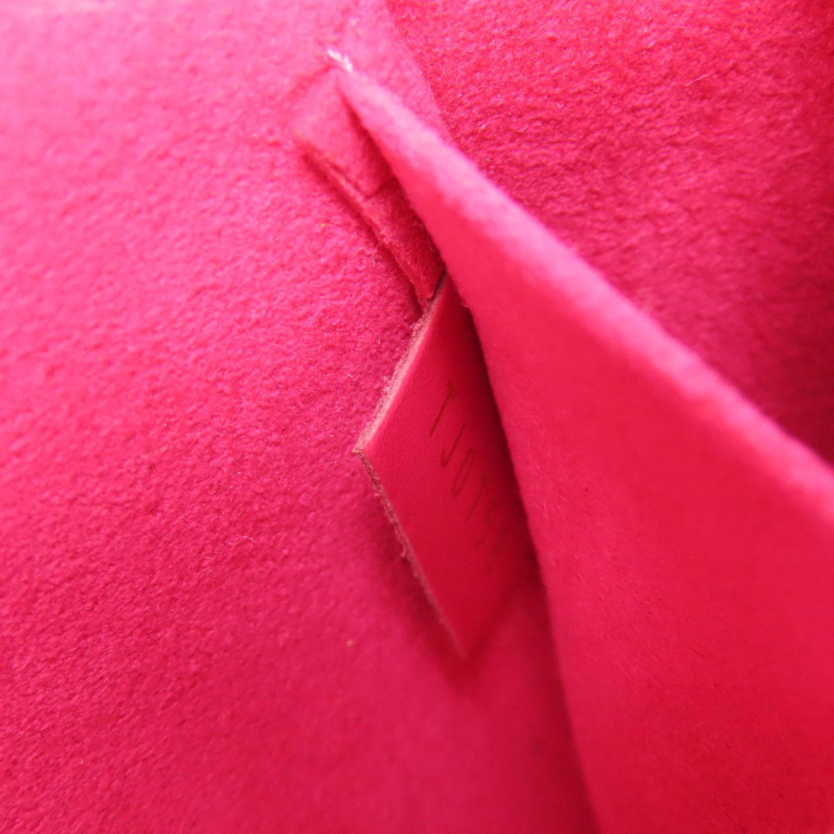 Close-up of pink fabric with a visible brand label.