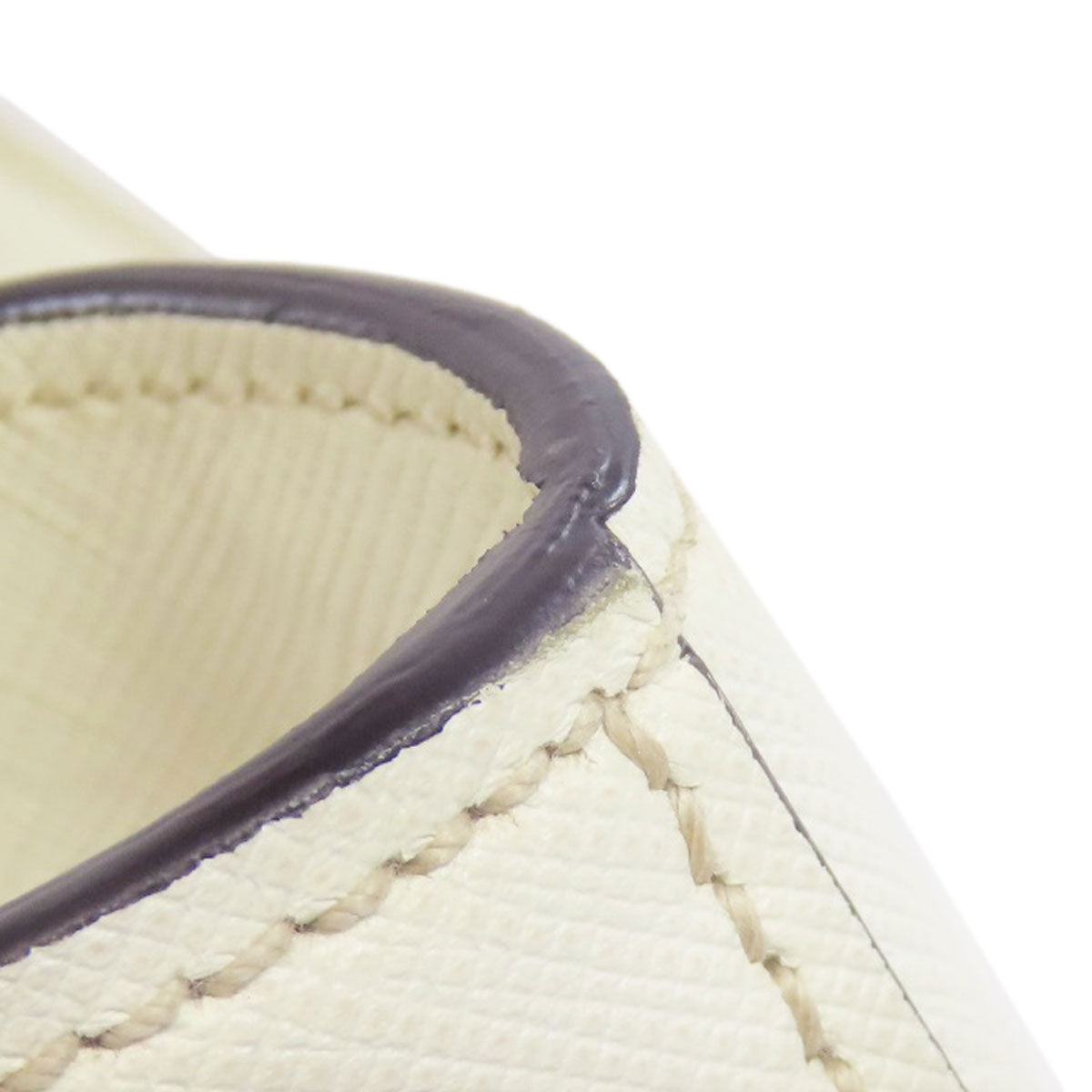 Close-up of a beige fabric with dark brown trim on a white background