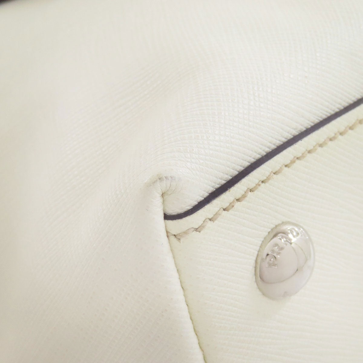 Close-up of a white fabric with a brand logo on a light gray background