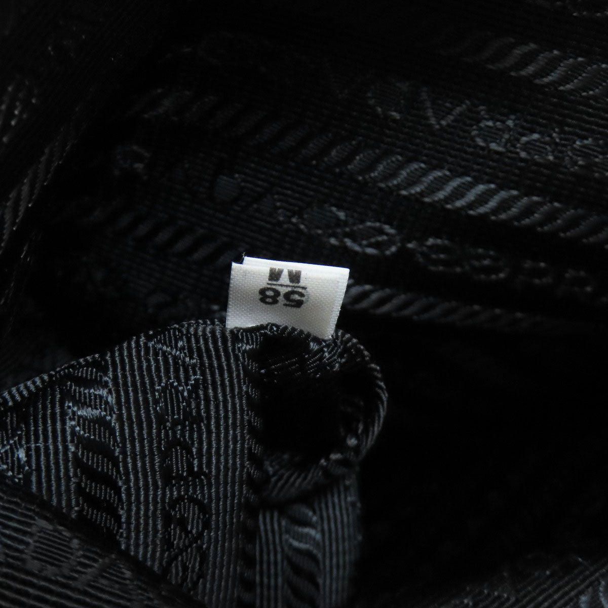 Close-up of a black textured fabric with a size label on a dark background