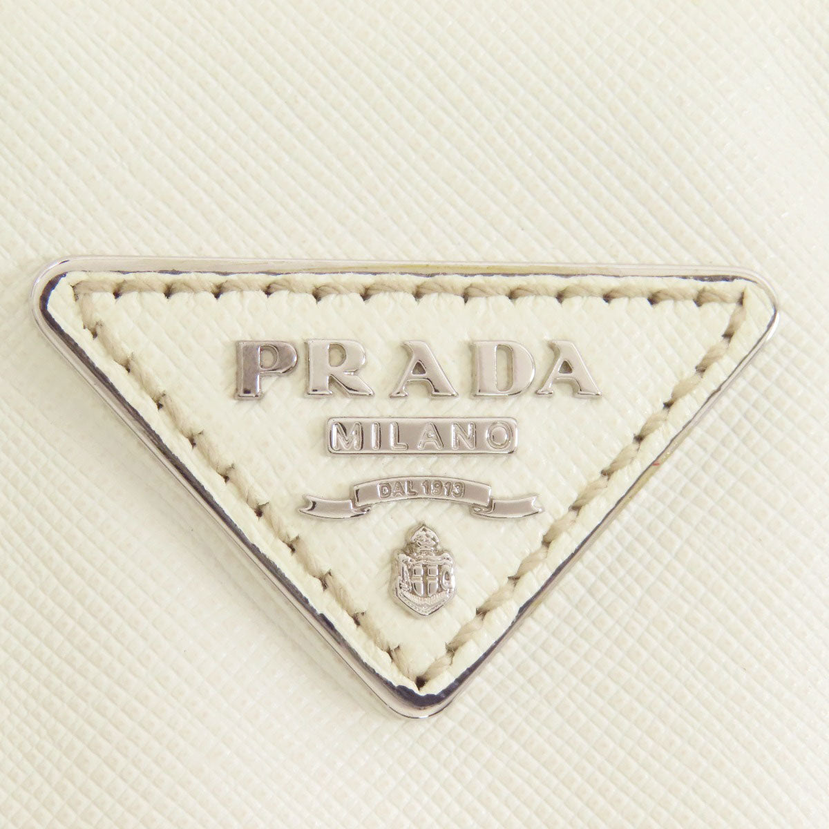 Close-up of a Prada logo on a textured white background
