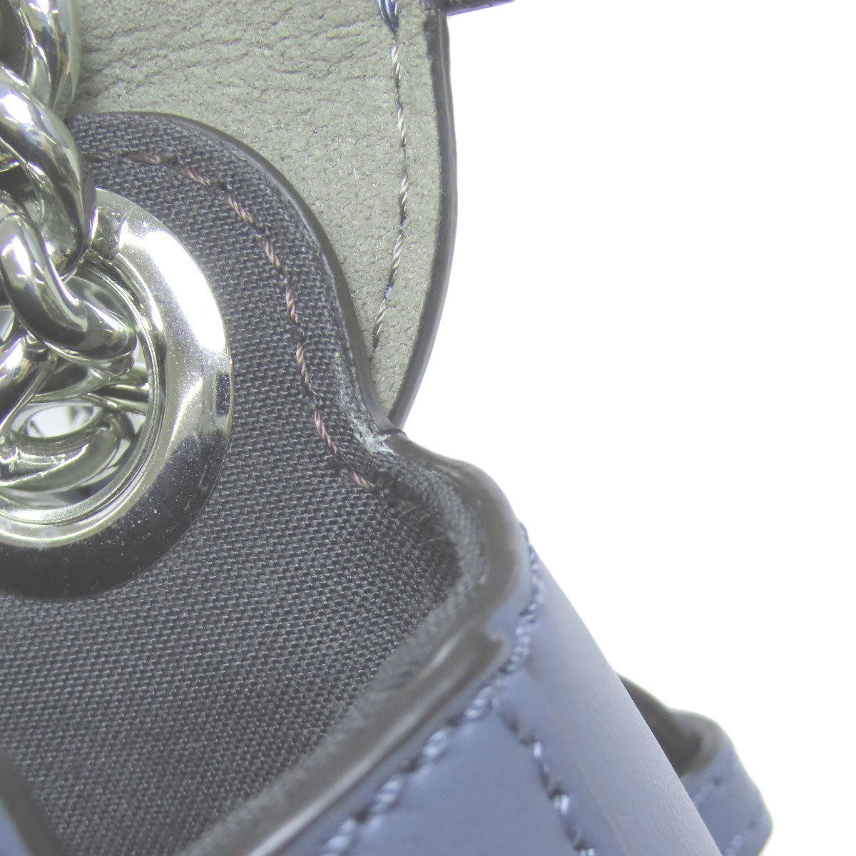Close-up of a textured surface with a metallic chain detail on a white background