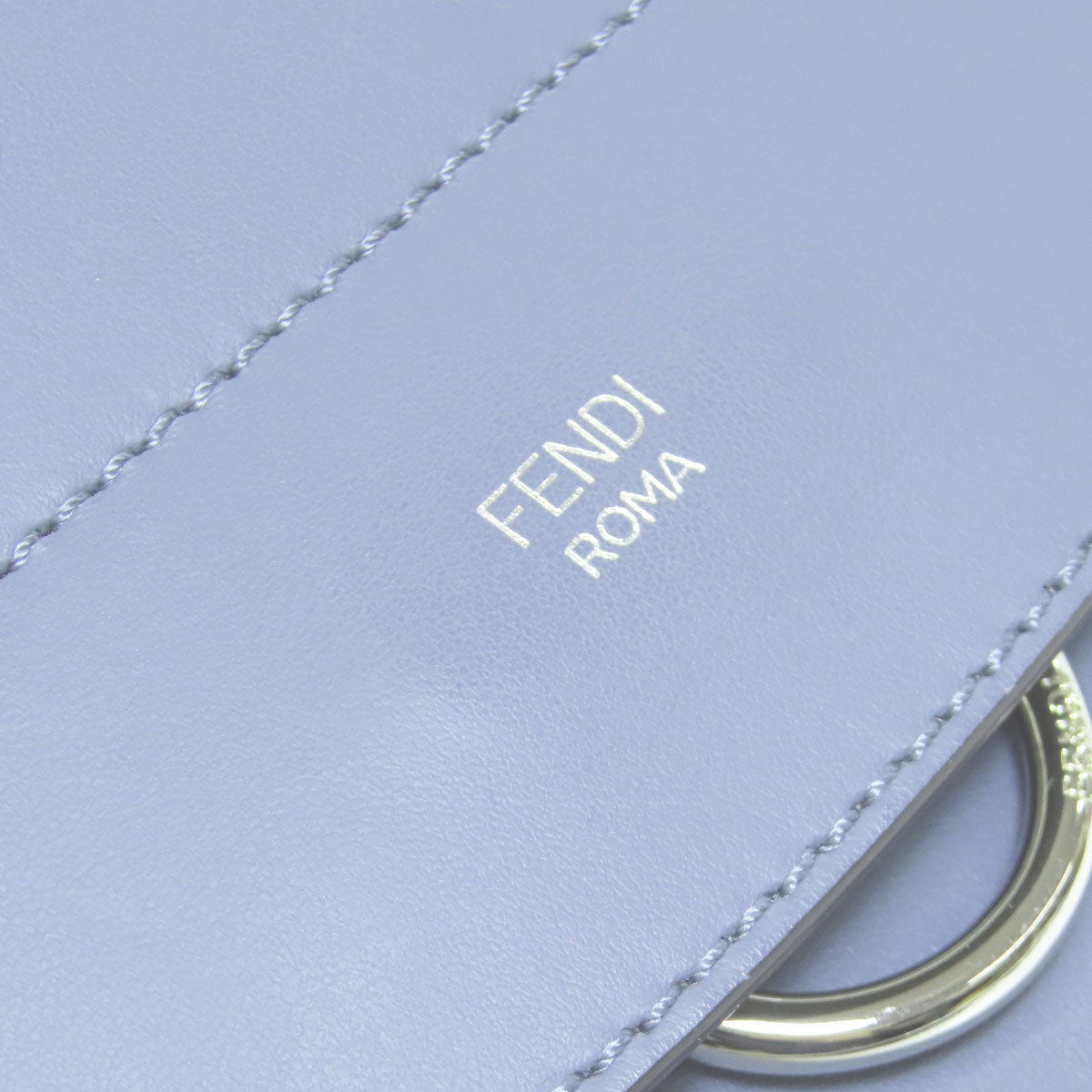 Fendi logo on a light blue background with gold hardware
