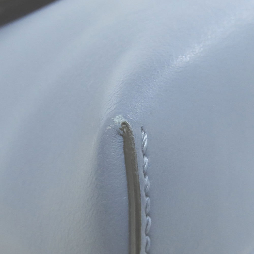 Close-up of a white leather surface with a visible seam.