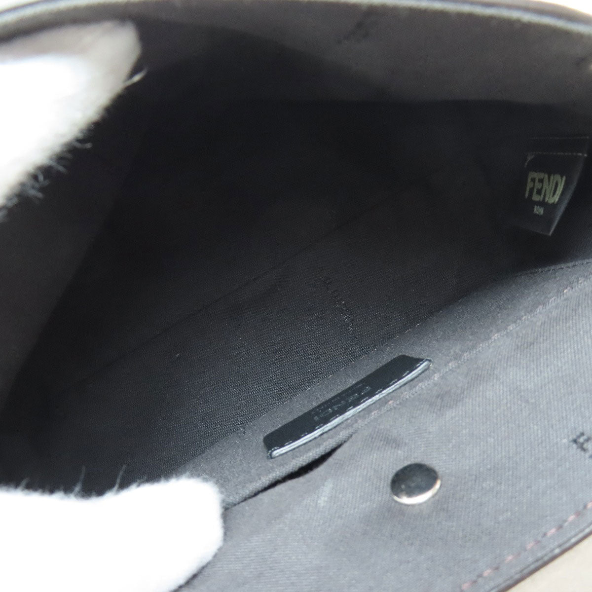 Close-up of a black leather bag with 'Fendi' branding inside.