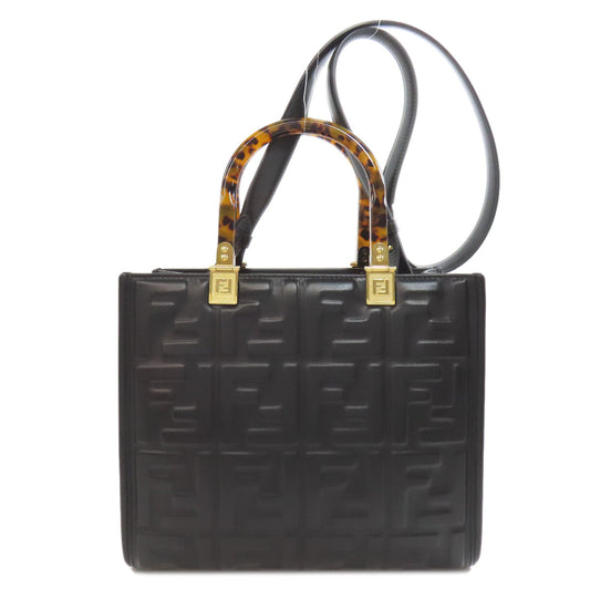 Black handbag with tortoiseshell handles on a white background