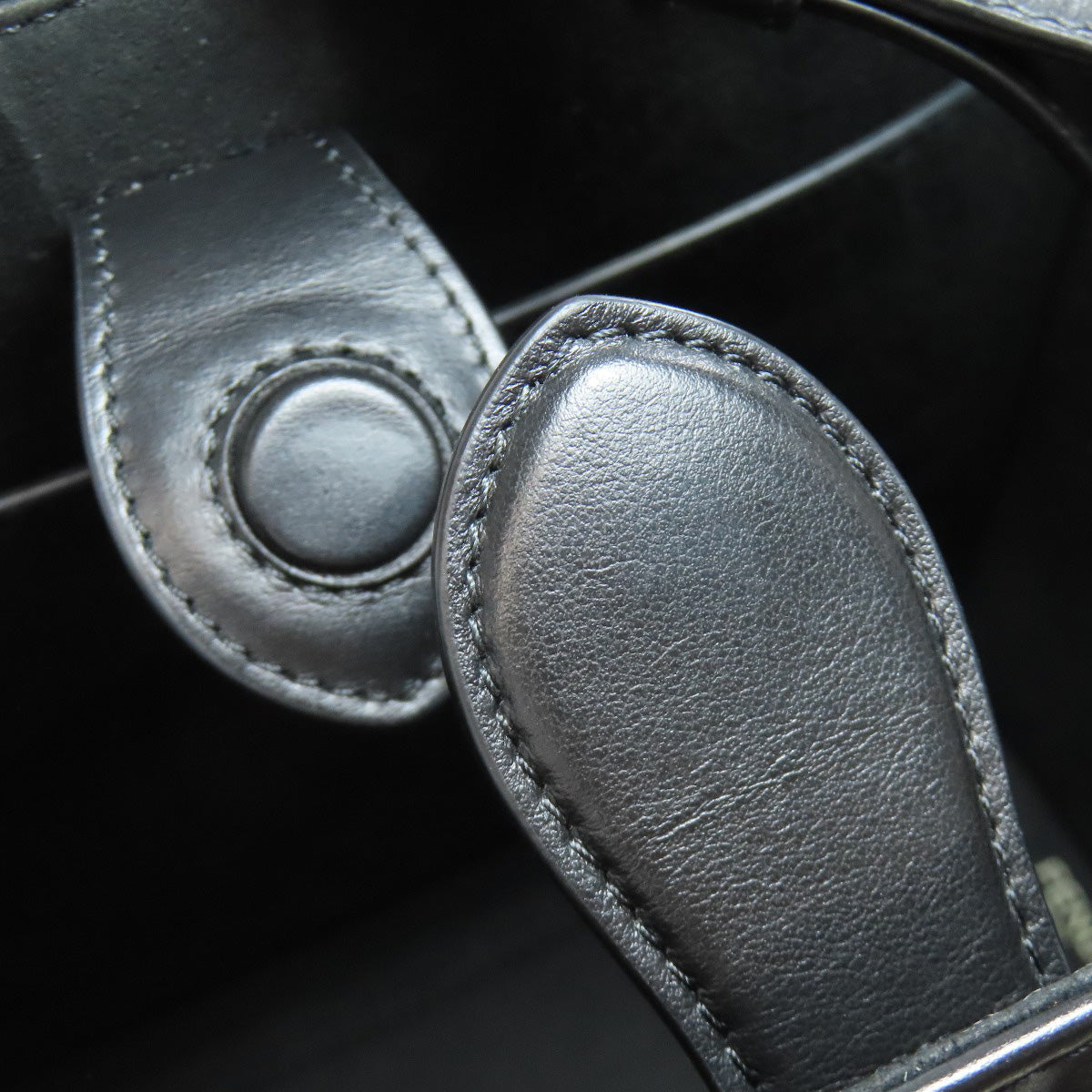 Close-up of a black leather guitar strap with stitching detail.